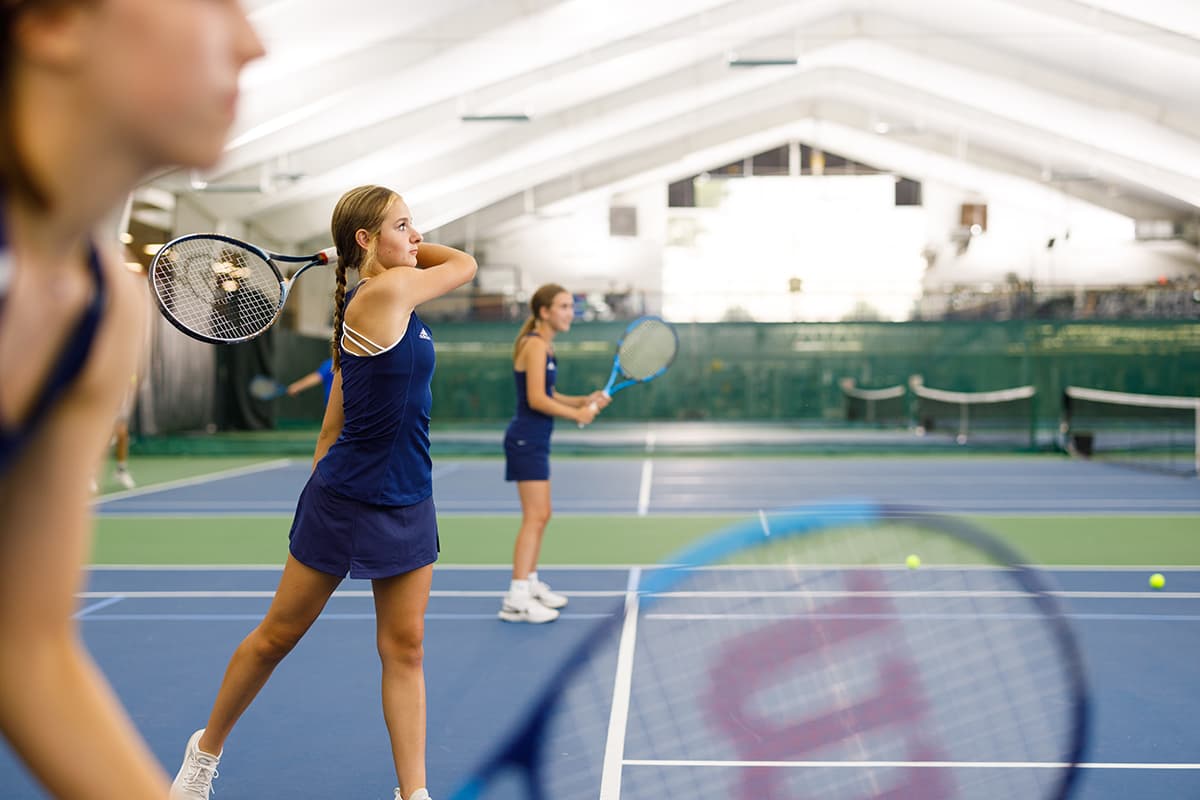 Girls play advanced tennis in lesson