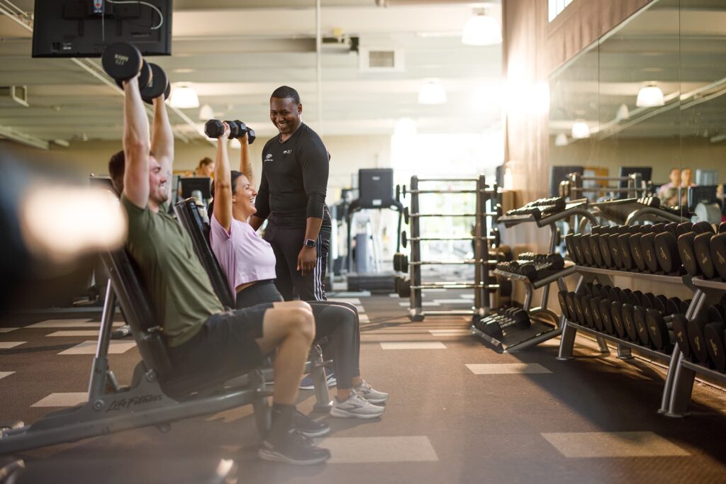 Trainer helps members in the fitness center