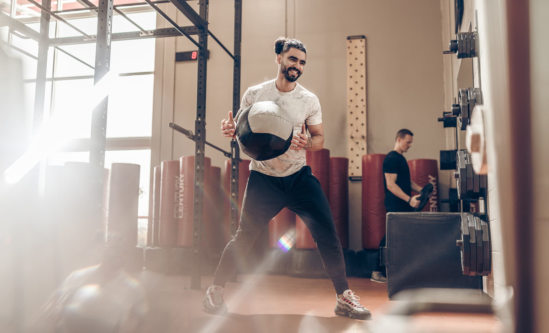 Man uses slam ball in fitness center