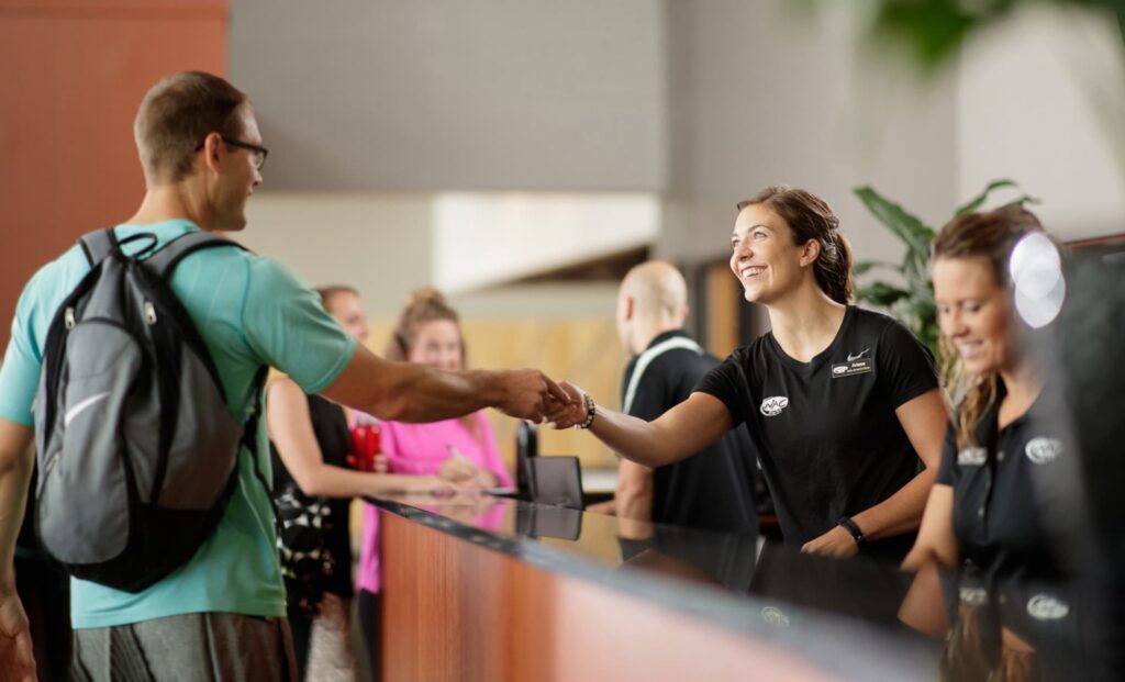 Front desk staff member greets guest