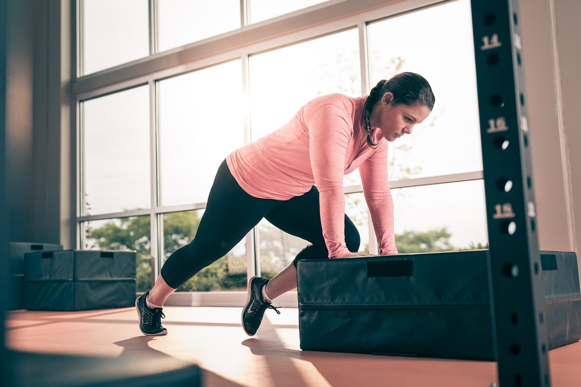 Woman does mountain climber exercise on plyometric box