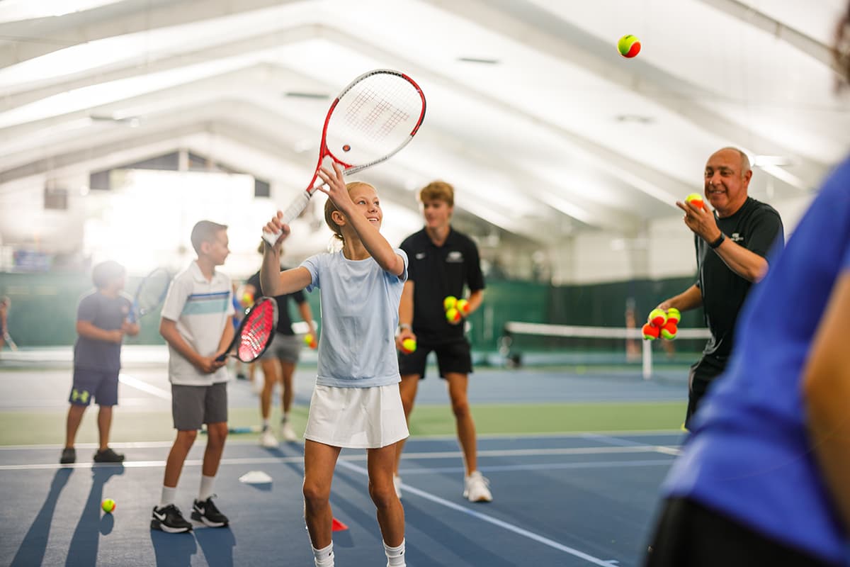 Young girl plays intermediate tennis in lesson