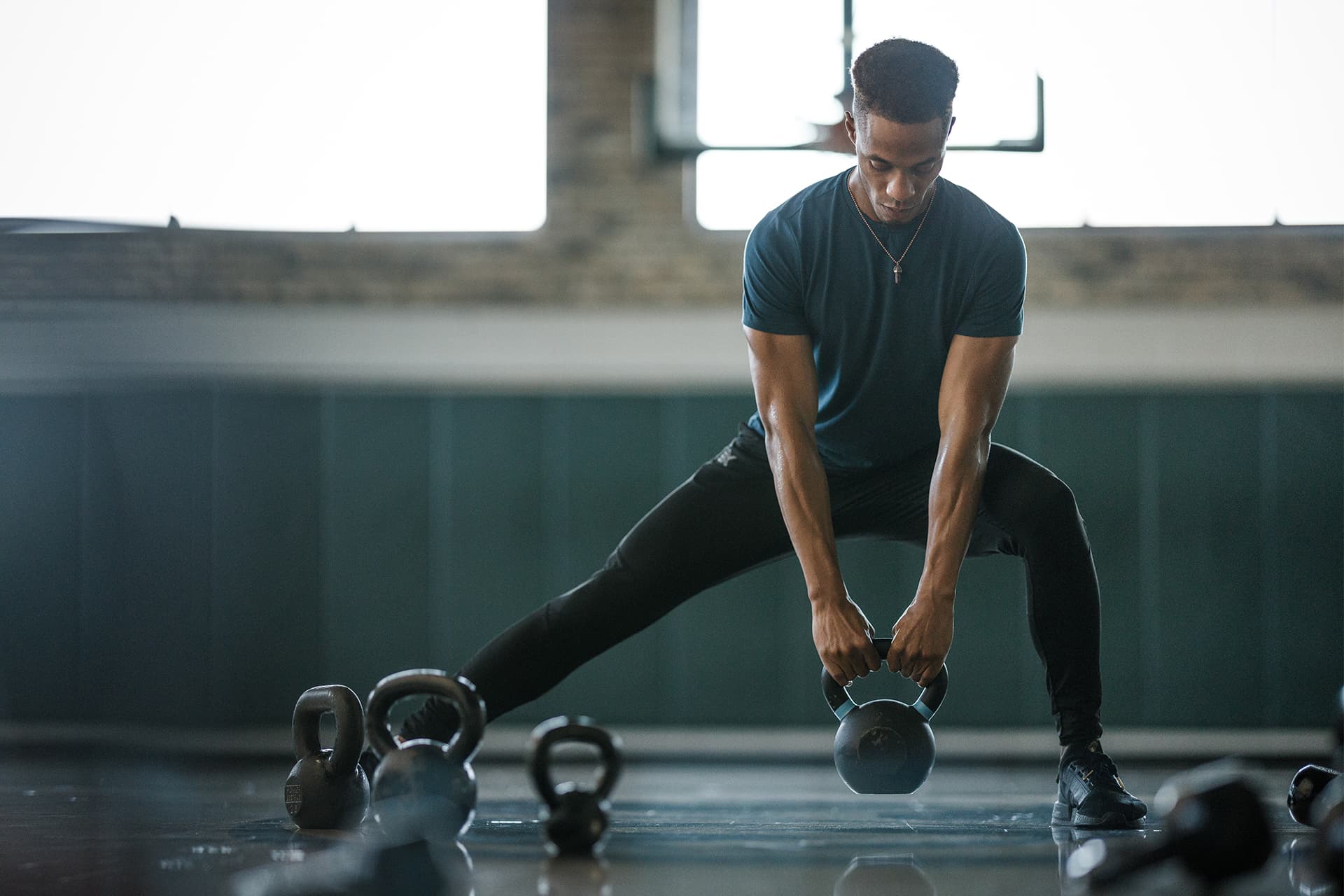 Man does kettlebell side lunge