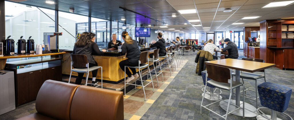 Lobby and club pub at WAC Lake Country. Lounge with seating towel racks and space to see the tennis courts. Full-service bar