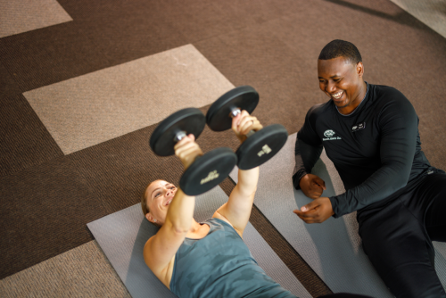 A man and woman participate in a joint workout session, showcasing collaboration and physical activity.