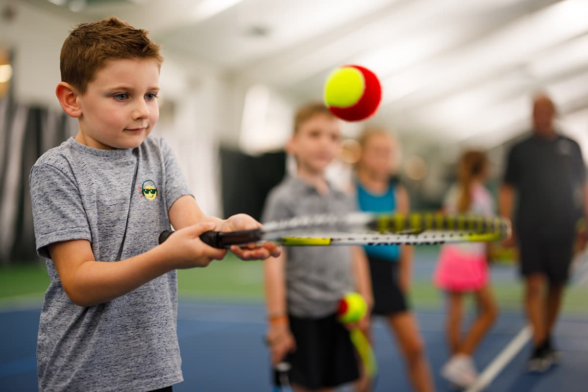 Young child learns to play tennis