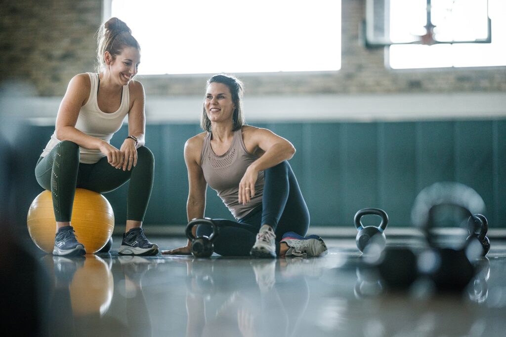 Women work out together in a large fitness area