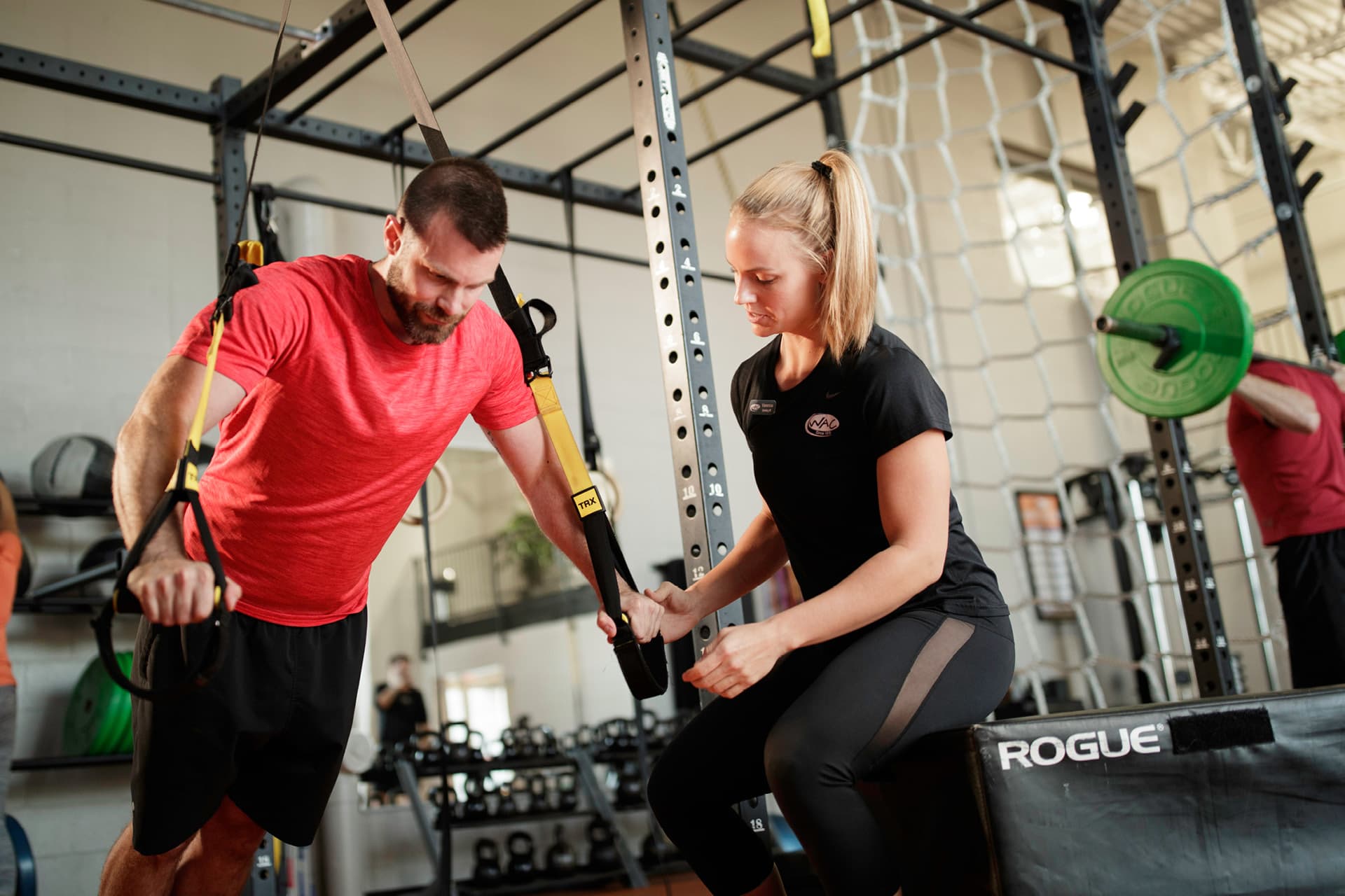 Woman trains man on TRX